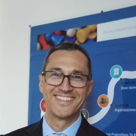 a man in a suit and tie standing in front of a poster