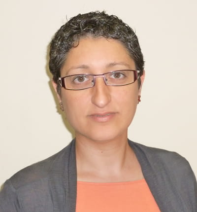 a woman wearing glasses and an orange top