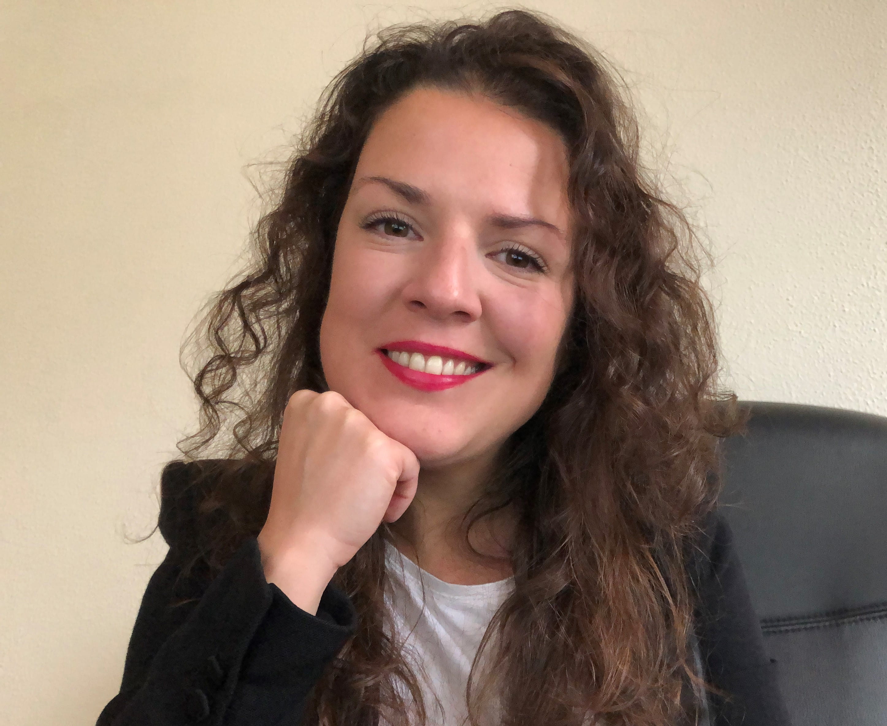 a woman with curly hair smiling