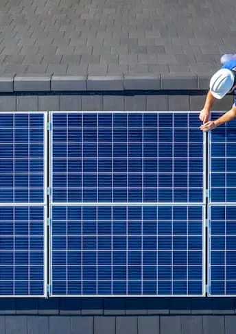 a man is installing solar panels on a roof