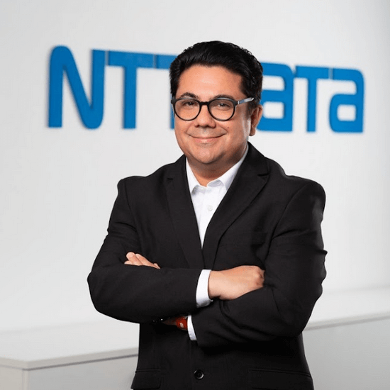 un hombre con un traje de pie frente al logotipo de NTBA