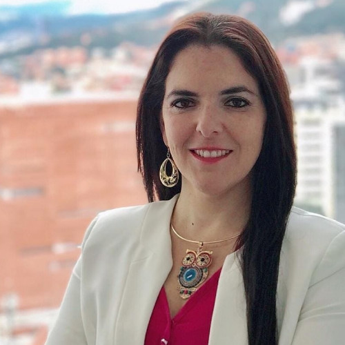 Una mujer que lleva un blazer blanco y una camisa rosa