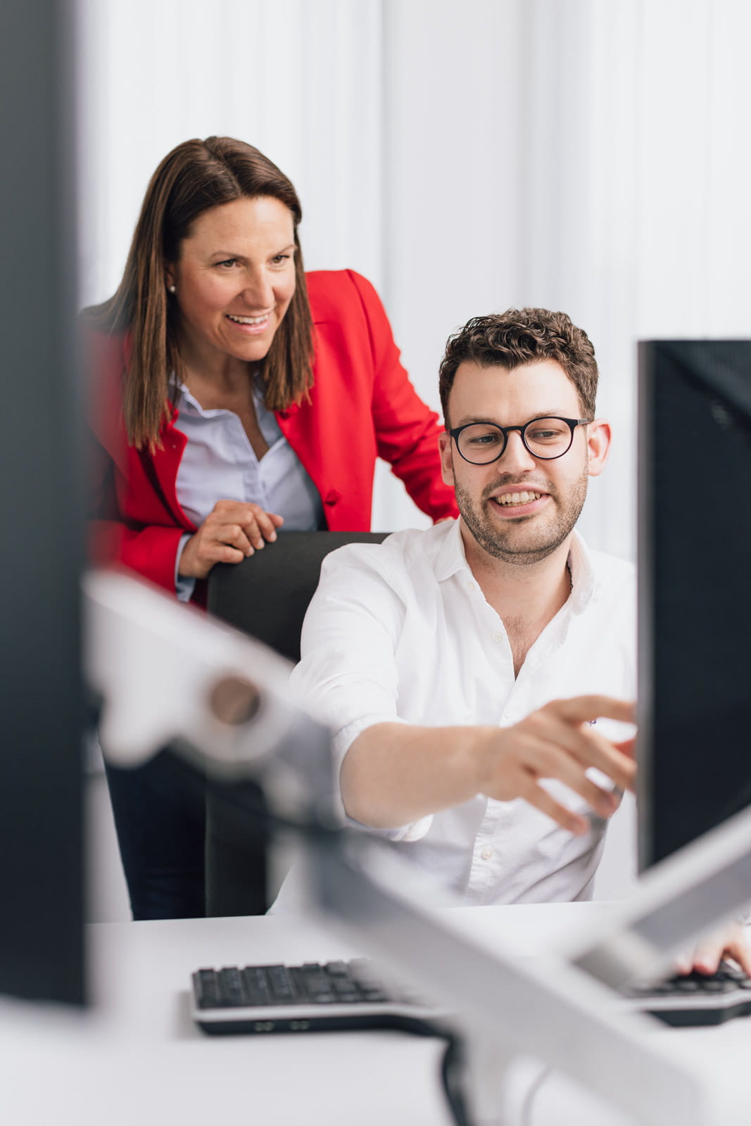 Eine Frau und ein Mann vor einem Computer