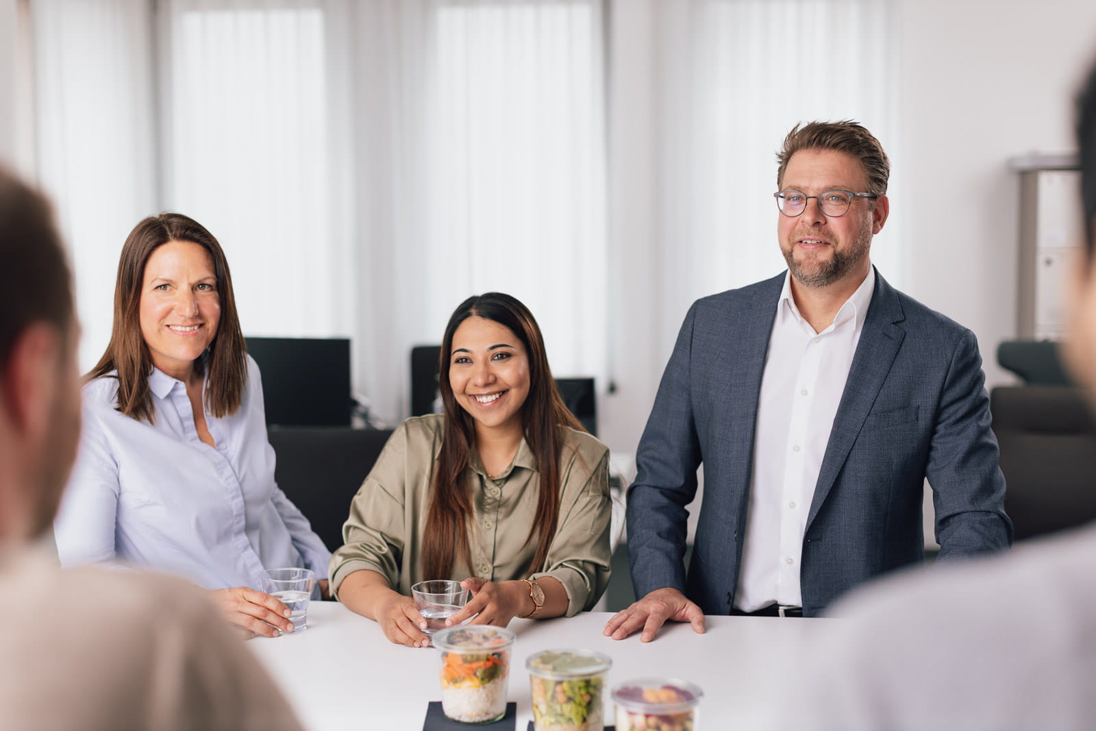 Eine Gruppe von Menschen, die an einem Tisch in einem Büro sitzen