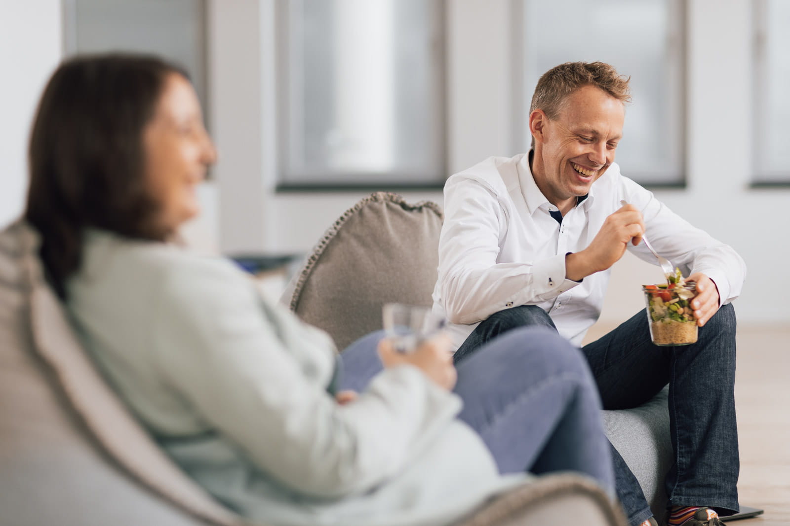 Ein Mann und eine Frau, die in einem Büro auf Bohnensäcken sitzt