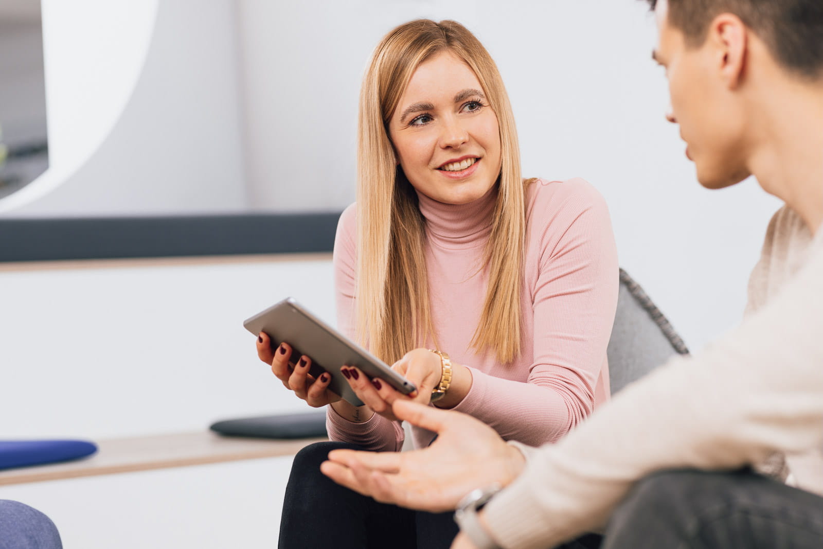 Eine Gruppe von Menschen, die in einem Raum sitzen und miteinander sprechen
