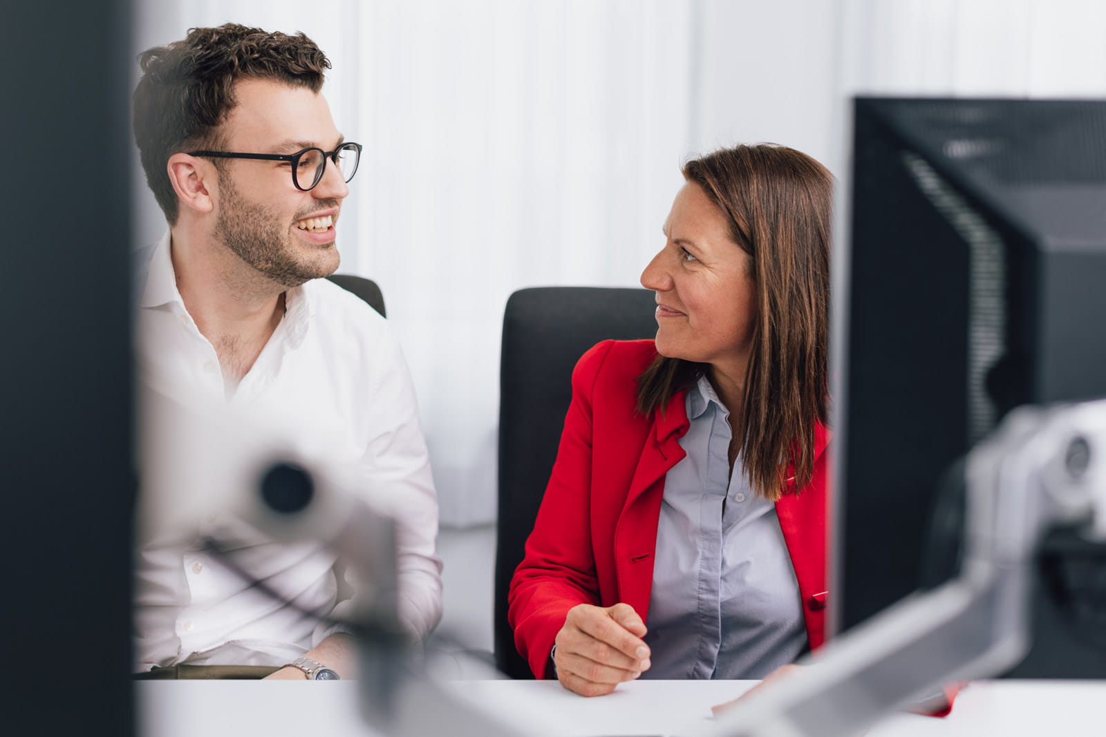 Ein Mann und eine Frau, die vor einem Computer spricht