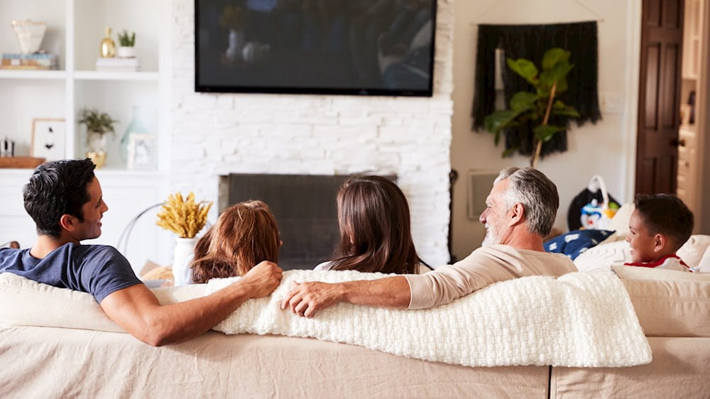 Media-Branche erfolgreich digitalisieren - Familie sitzt in einem Wohnzimmer vo einem Fernseher