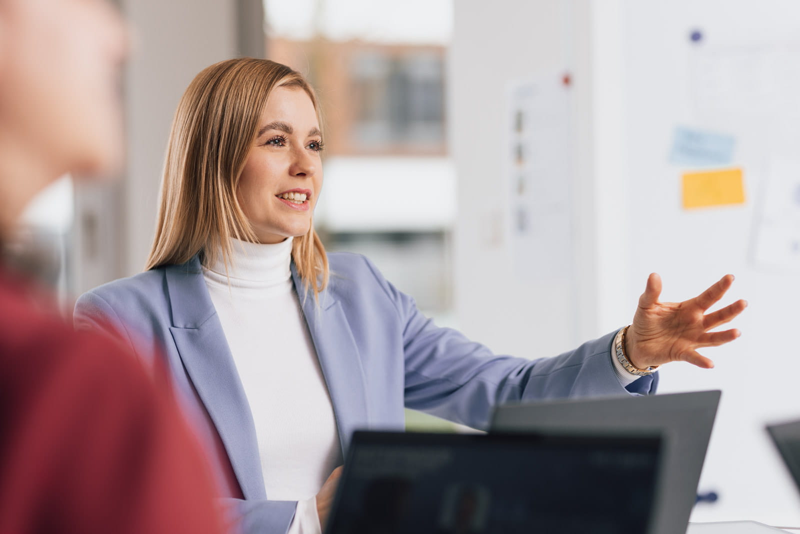 Eine Frau hält einer Gruppe von Menschen eine Präsentation