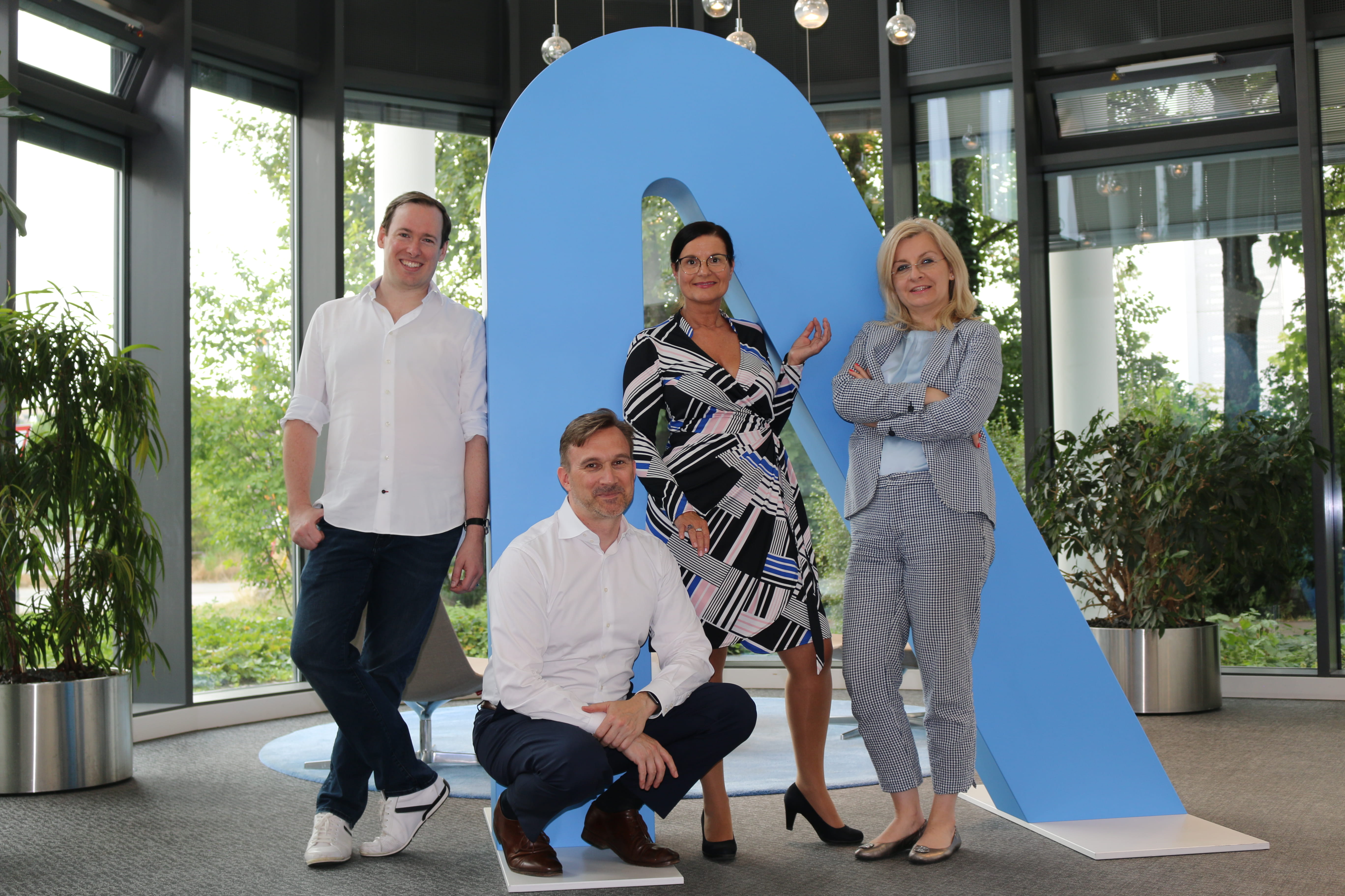 Eine Gruppe von Menschen, die vor einem großen Buchstaben a posieren