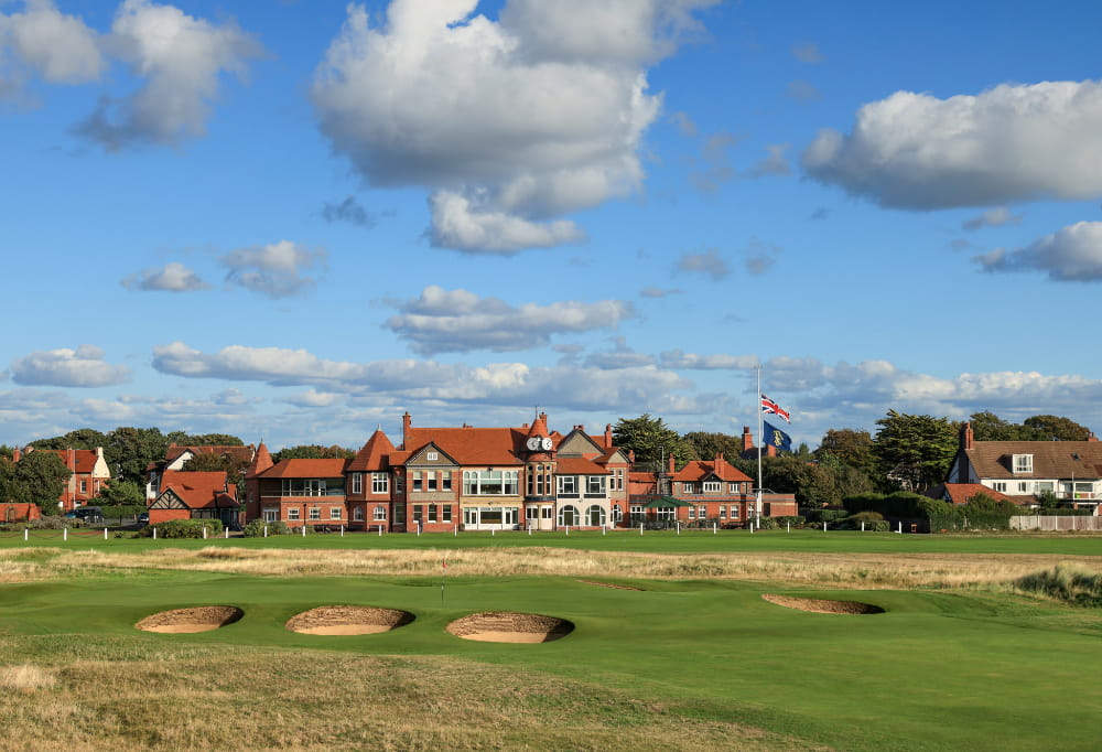 a golf course with a house in the background