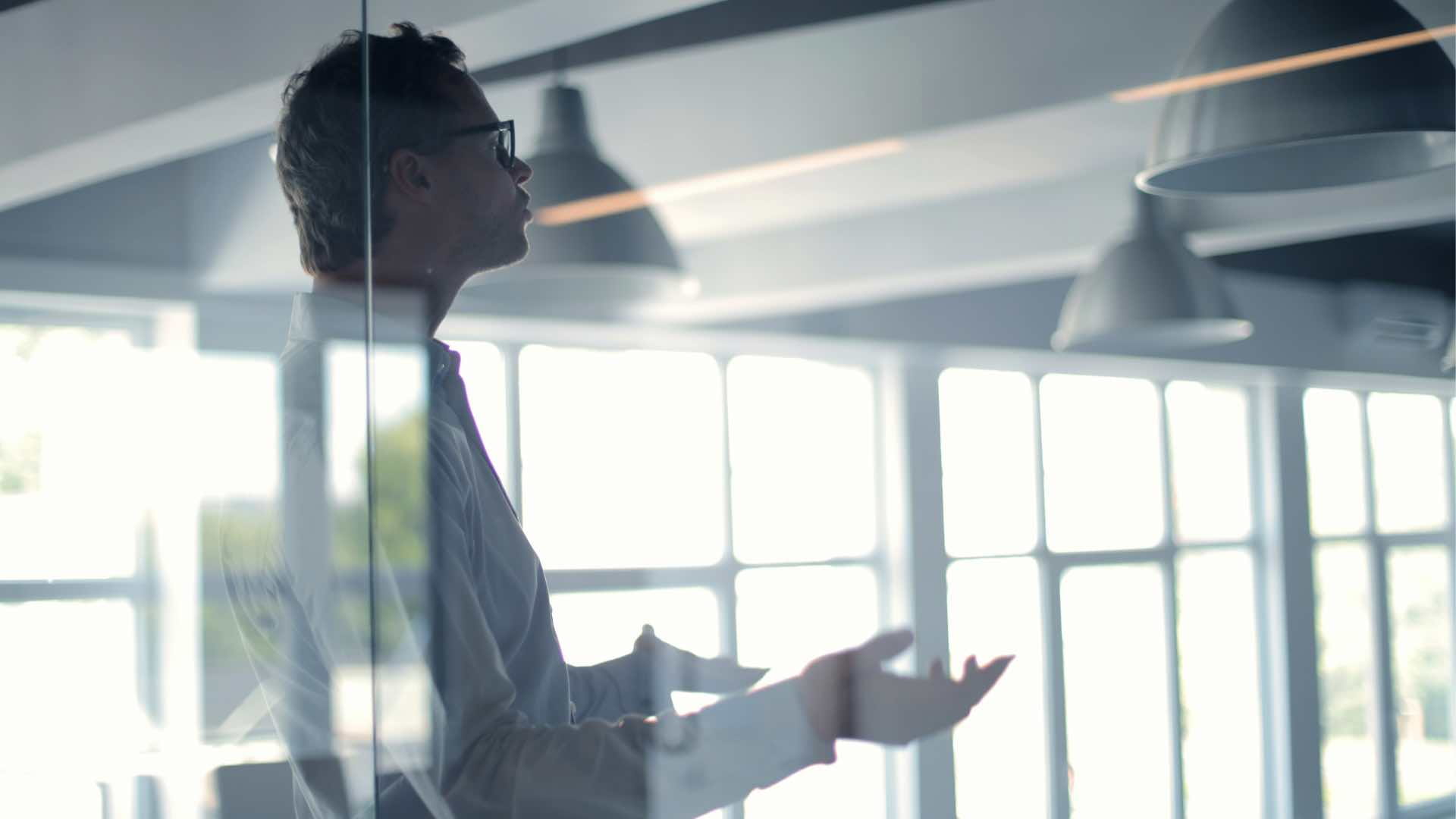 Uomo in piedi che fa un discorso in ufficio