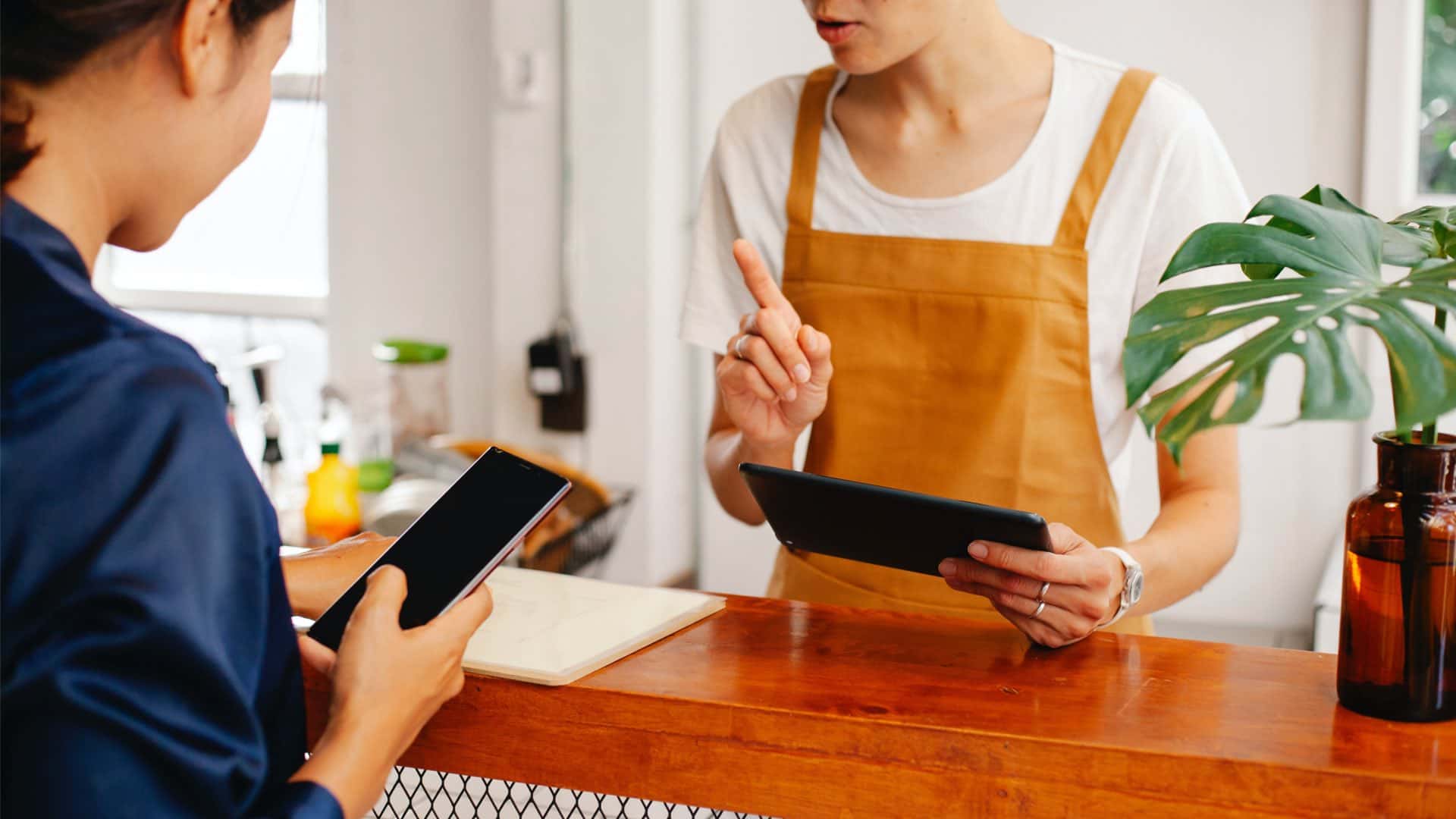 Cliente in un negozio che paga con il cellulare