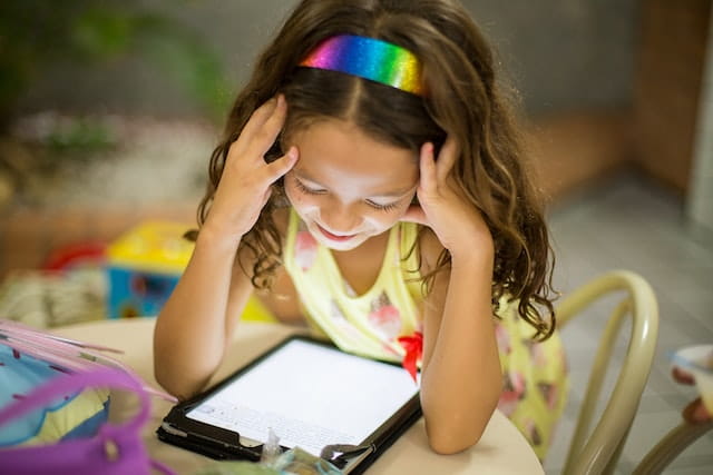 bambina che guarda un tablet