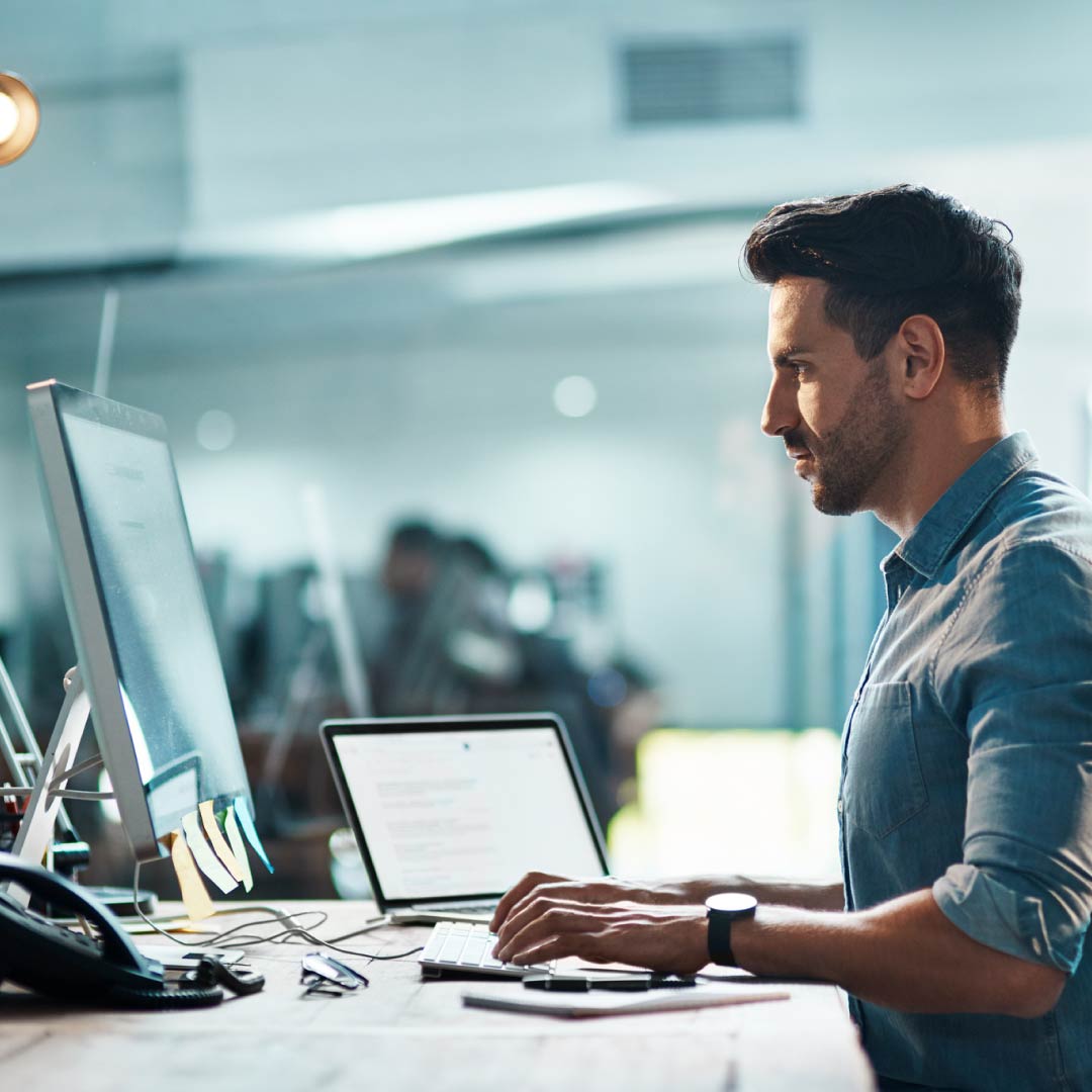 Un informatico lavora aggiornando più computer