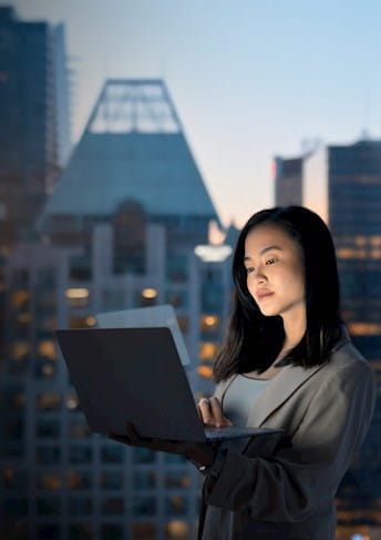 Ragazza usa un computer portatile, sullo sfondo dei grattacieli