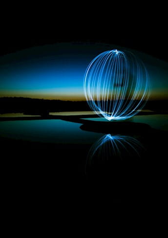 Sfera composta da fasci di luce su sfondo scuro