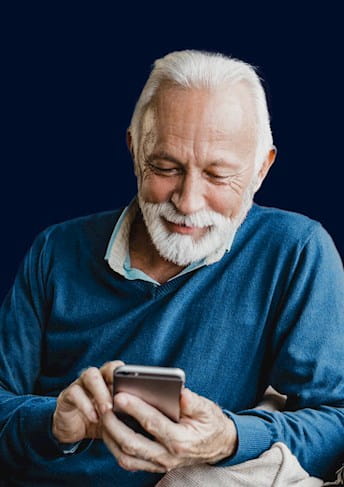 Uomo anziano seduto che usa lo smartphone