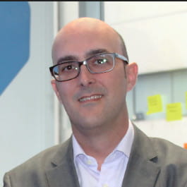 a bald man wearing glasses and a suit