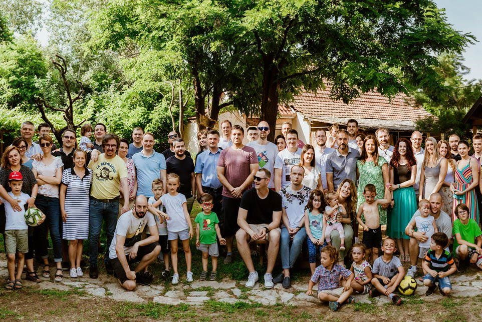 a group of people posing in front of a house
