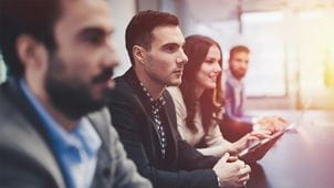 a group of people sitting in a conference room