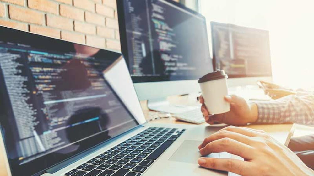a man working on a laptop with a cup of coffee