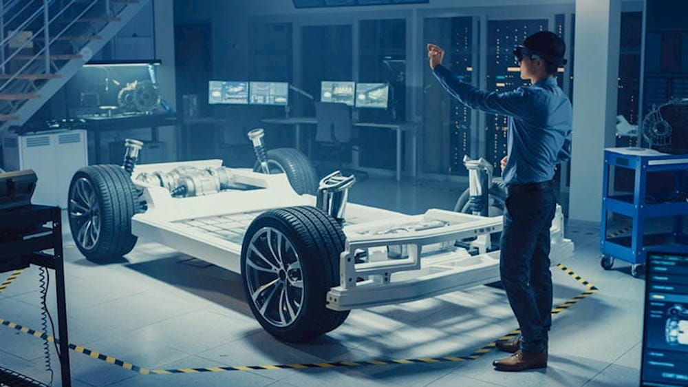 a man is standing in front of a car in a factory