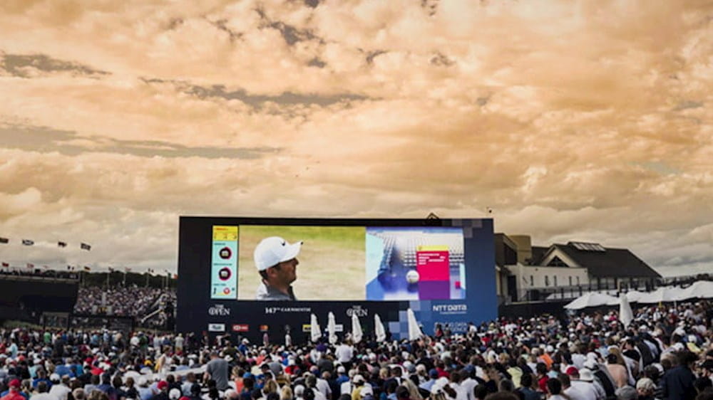 Fans watching golf on the big screen at the Open golf championships sponsored by NTT DATA