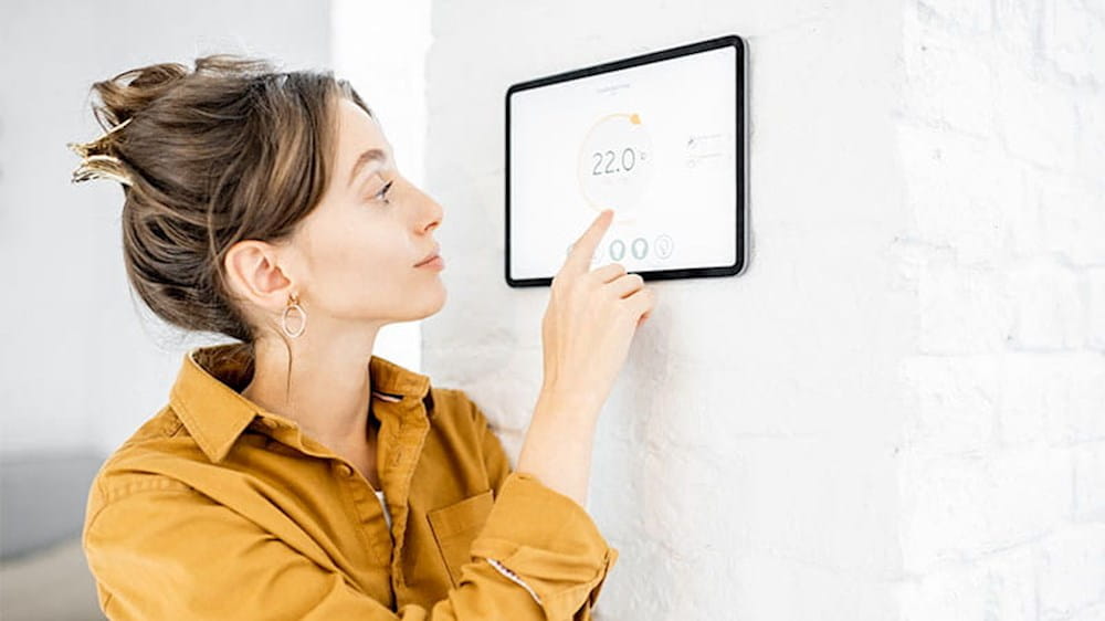 a woman looking at a digital thermosta
