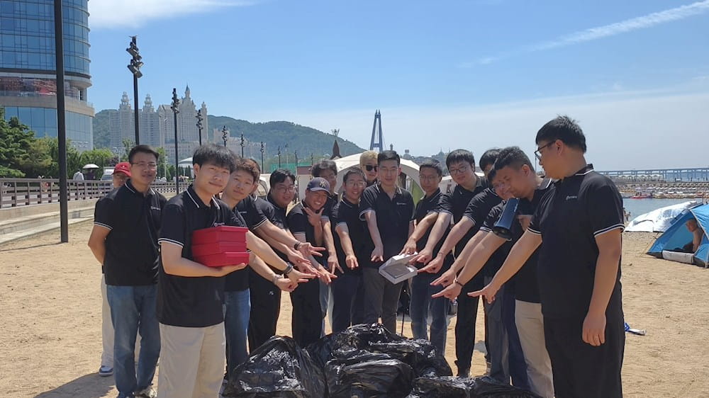 Group of people dressed in black after cleaning the beach.