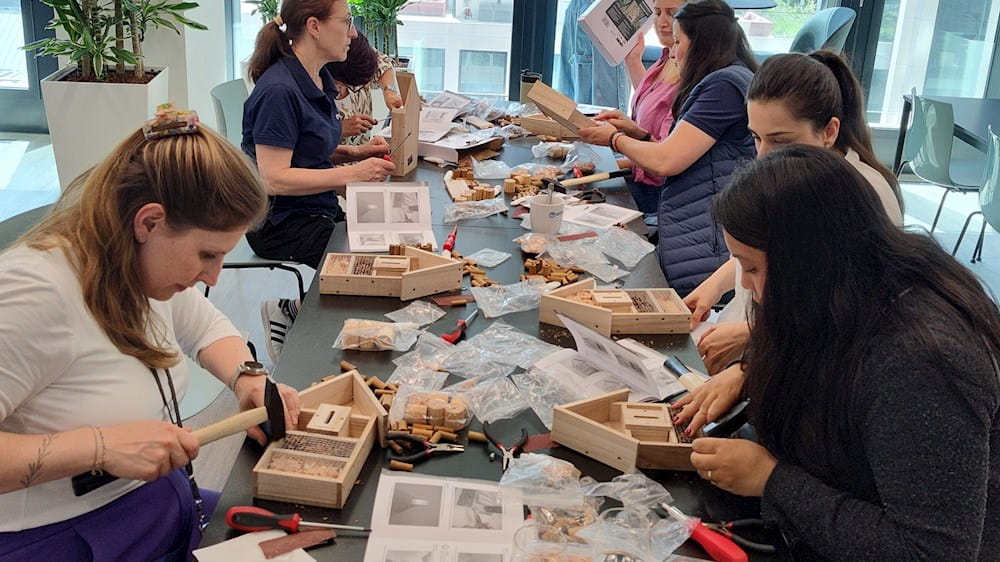 Group of young girls engaged in eco-friendly crafts around a table, using recycled materials for creative projects.