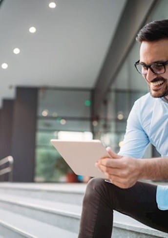 A banking employee is using a digital device to process a customer's remediation claim, showcasing a seamless and efficient workflow.