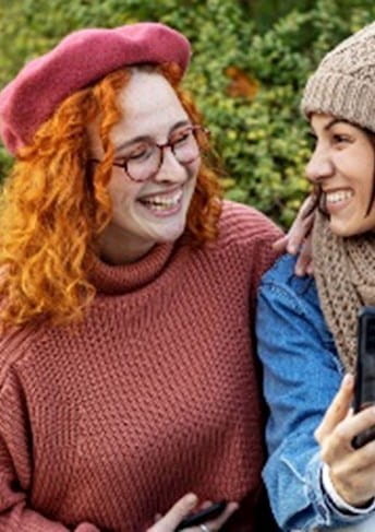 Two girls talking on a bench