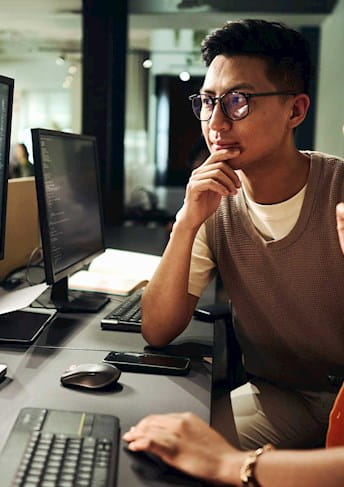 Woman and man reading data from a computer
