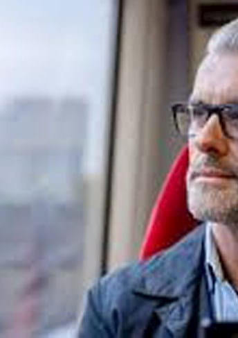 Hombre sentado en un tren mirando por la ventana
