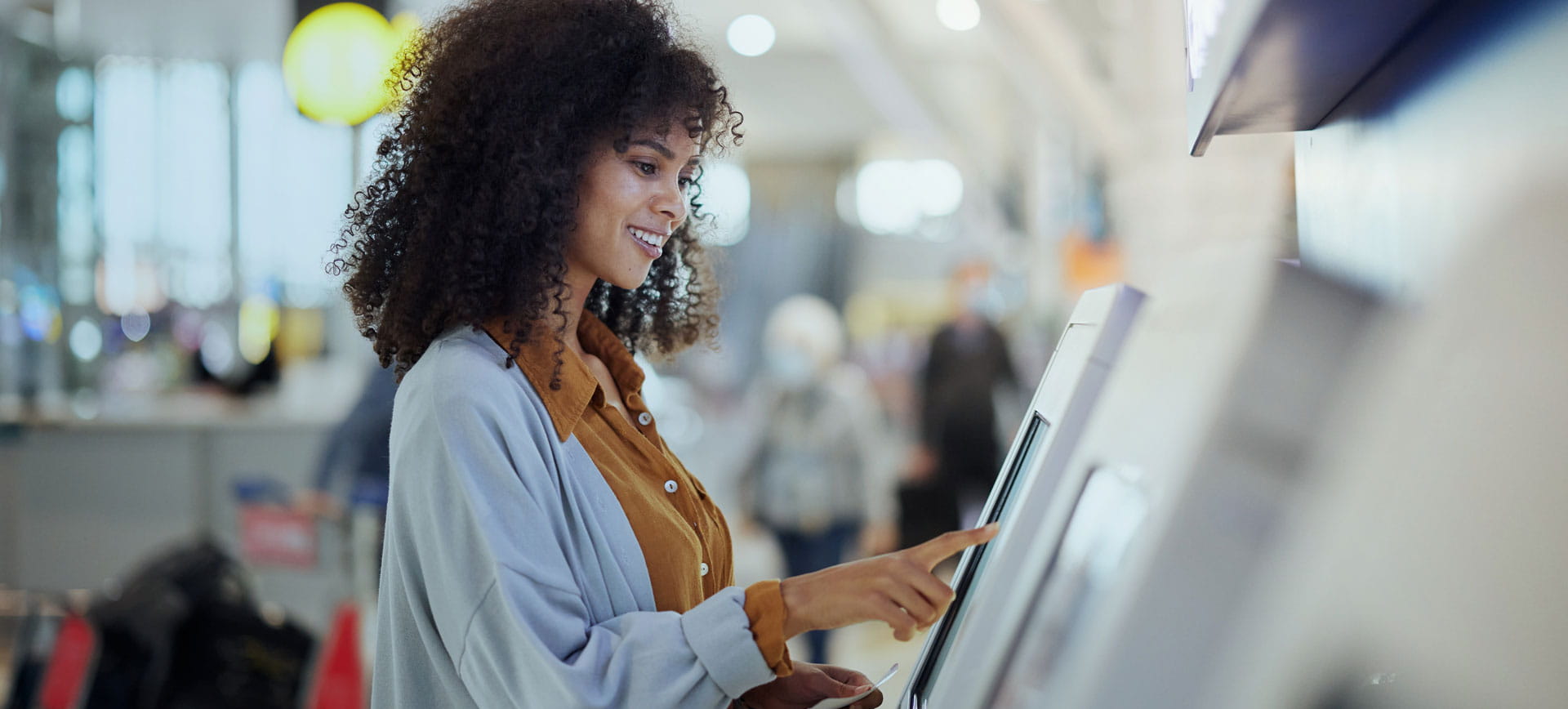 a woman using an atm machine at an airport