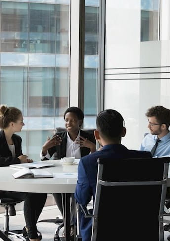 Menschen sitzen an einem Tisch im Büro