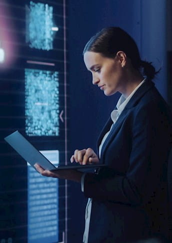 a woman using a laptop in front of a computer screen