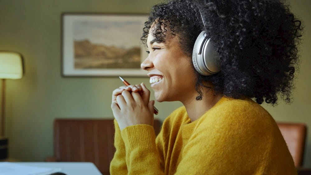 Woman with headphones in front of screen