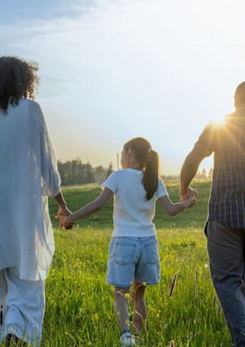Famiglia che cammina in un prato sotto il sole