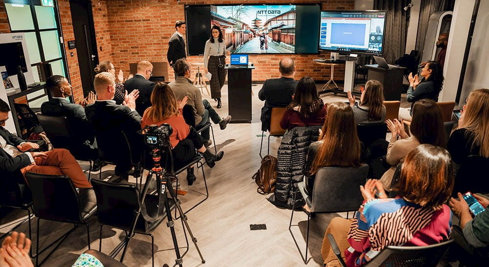a group of people in a room watching a presentation
