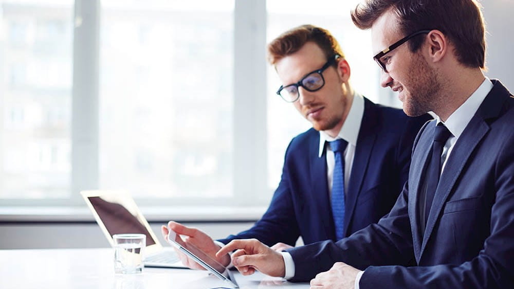 two businessmen looking at a tablet