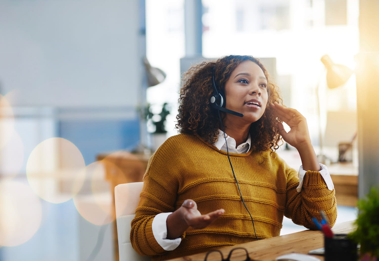 a woman in a headset talking to someone at a desk
