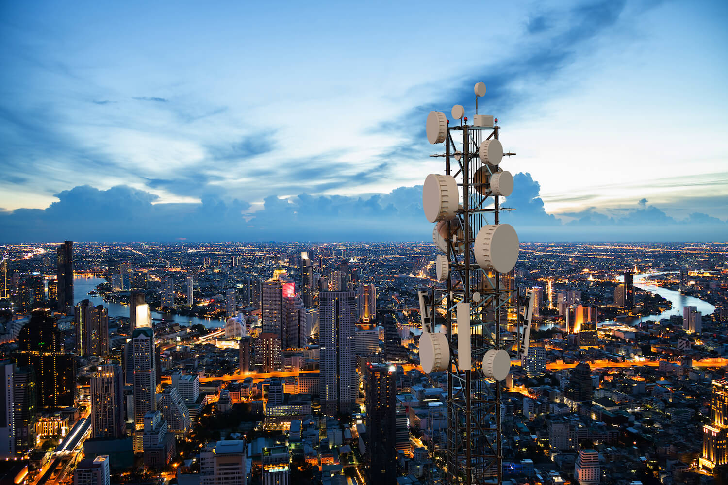 telecommunication towers in a city at dusk