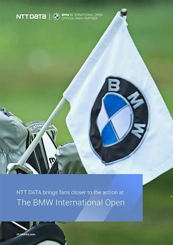 a golfer holding a flag at the bmw international open
