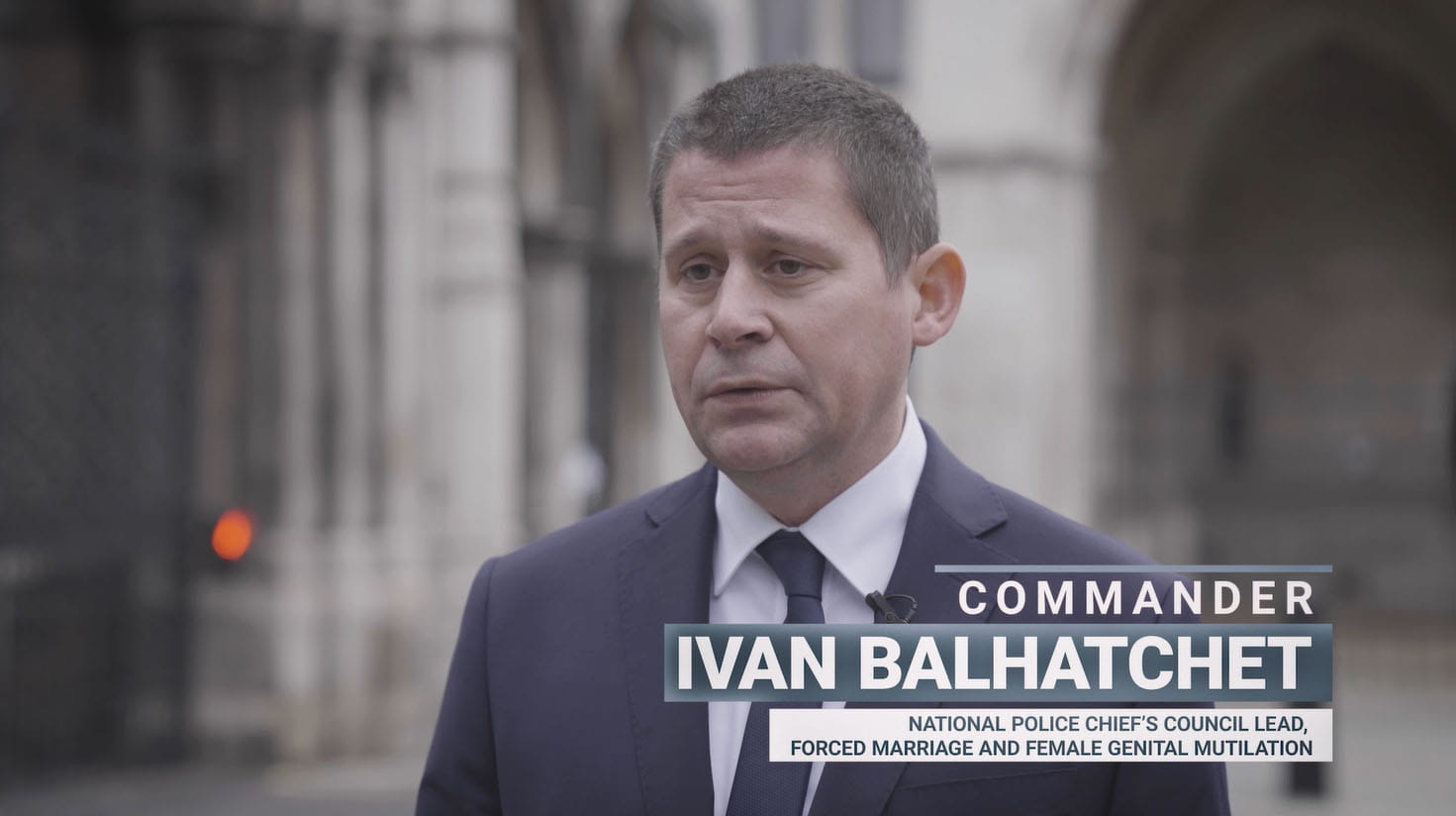 a man in a suit is standing in front of a building