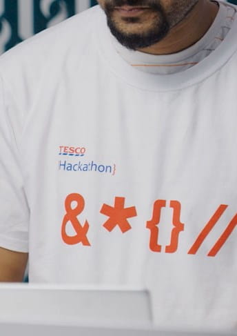 a man wearing a white t - shirt working on a laptop