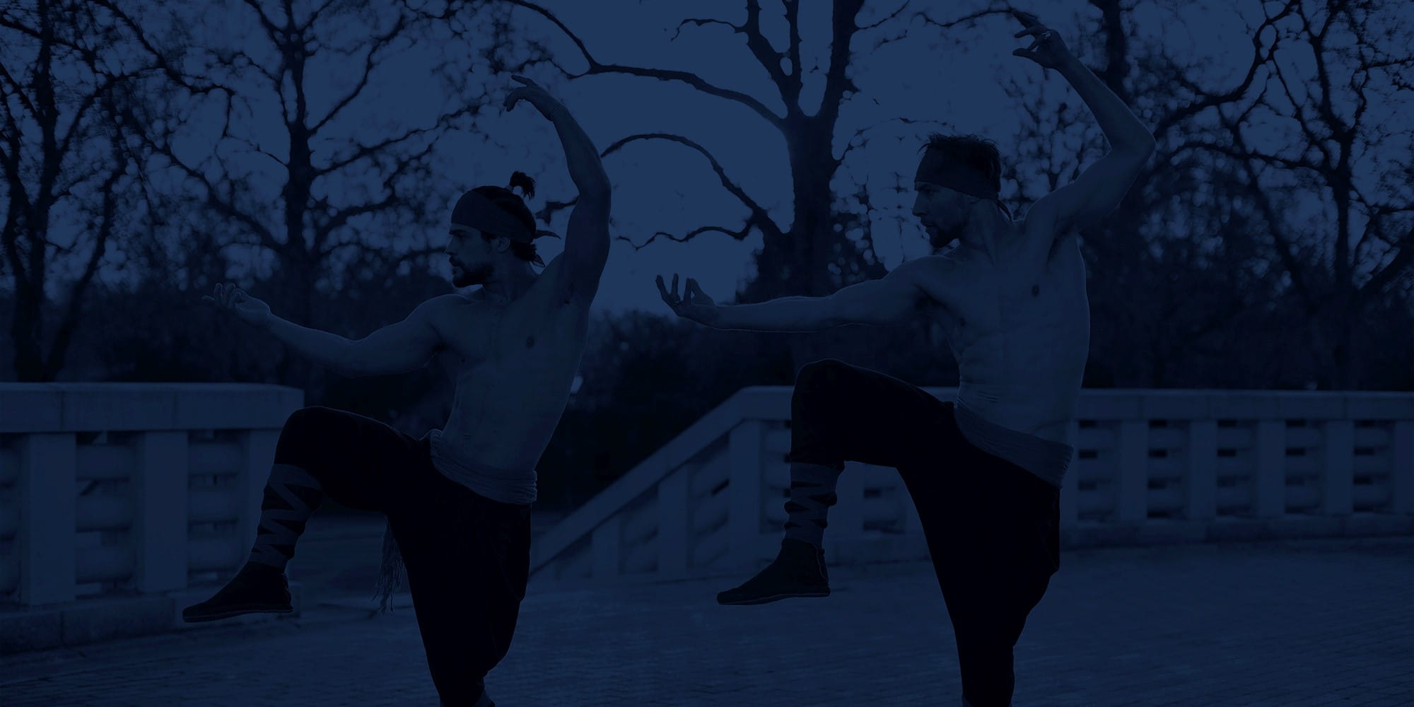 two men doing martial arts in the dark