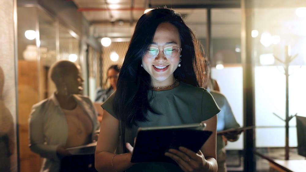 a woman is using a tablet in an office