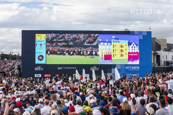 a crowd of people watching a large screen